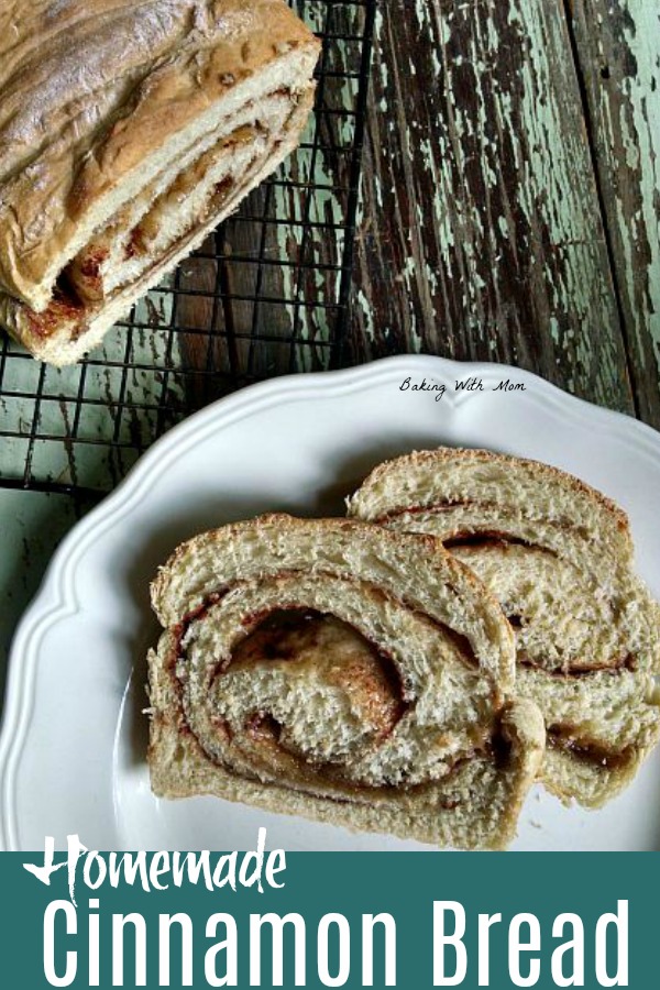 Homemade cinnamon bread on a white plate with a cooling rack nearby