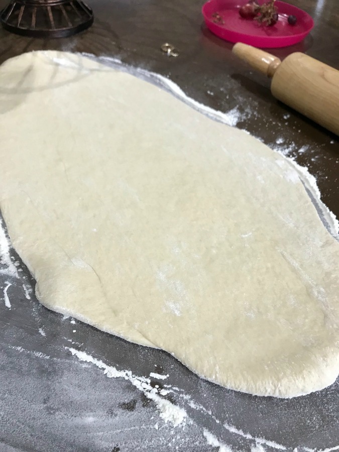 Rolled out dough on a counter with a rolling pin