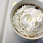 Homemade hot chocolate mix in a white cup with whipped cream on top