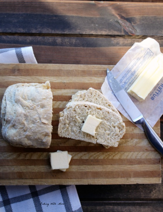 Handmade Oatmeal Bread on a cutting board with butter