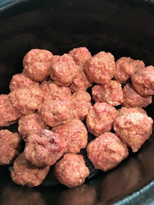 Uncooked meatballs in a crockpot