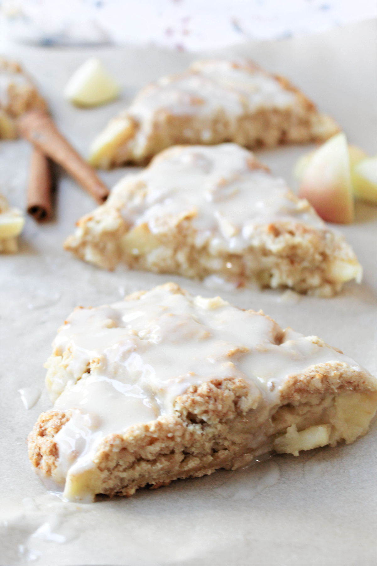 apple cinnamon scones with cinnamon sticks beside.