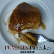 pumpkin pancakes on a white plate with syrup.