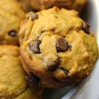 Pumpkin Chocolate Chip Muffins in cream bowl on white towel