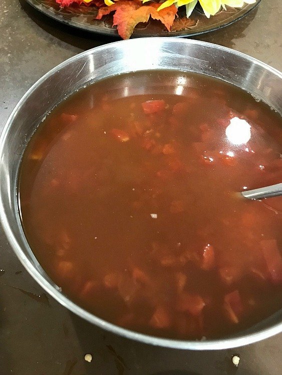 Beef broth in a bowl with tomatoes