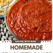 Homemade spaghetti sauce in a clear bowl with pasta behind.