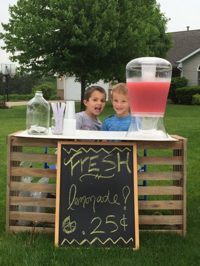 two boys with lemonade stand. 