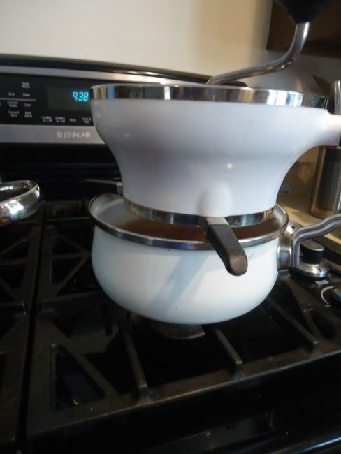 Apple mill over a pot on a stove.