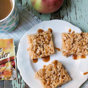 Crispy apple cider treats with a caramel drizzle on a white plate. Apple cider in a white mug