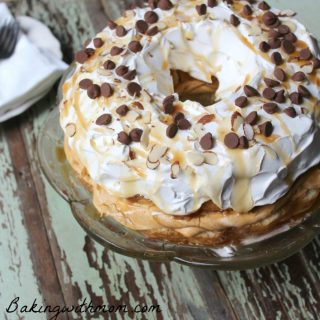 Pumpkin cake on a cake serving dish with whipped cream and chocolate chips on top
