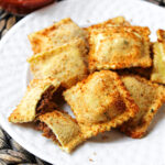 air fryer toasted ravioli on a white plate.