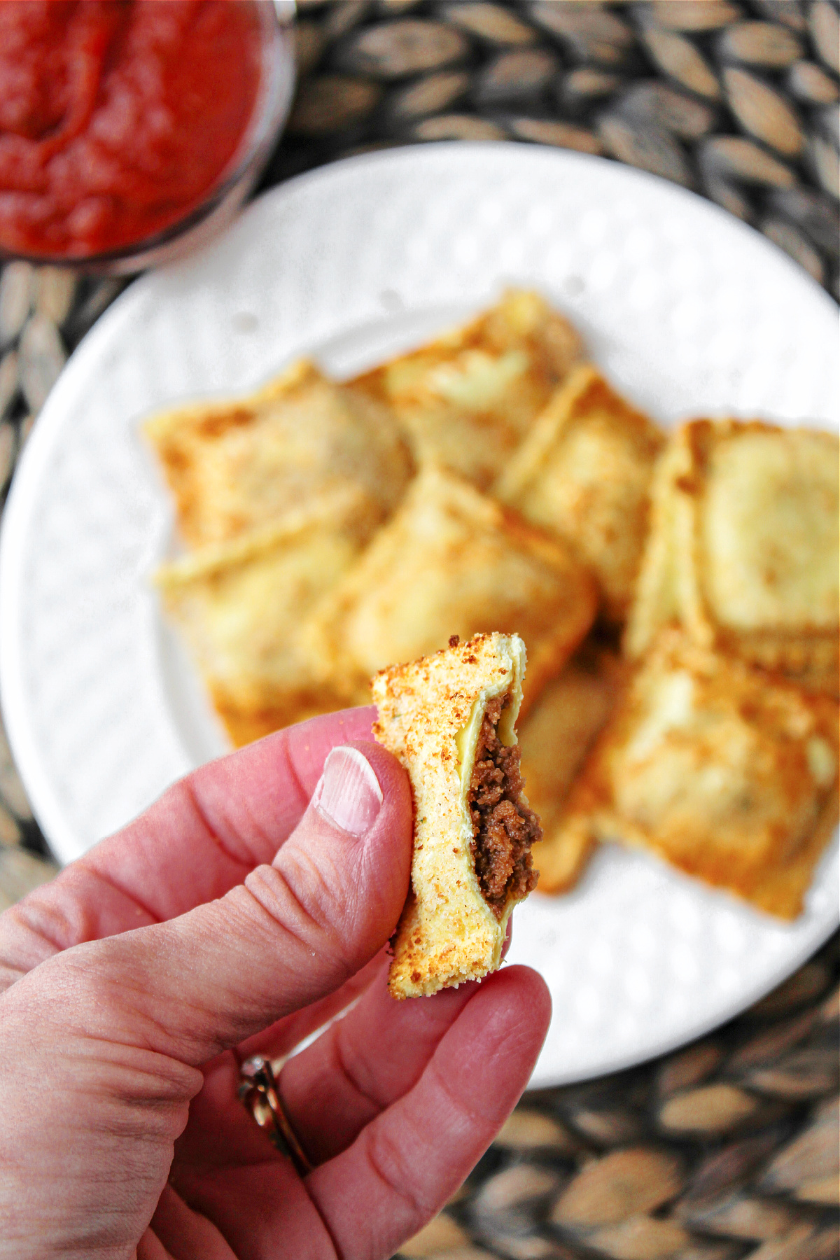 Beef ravioli being held by a hand. 