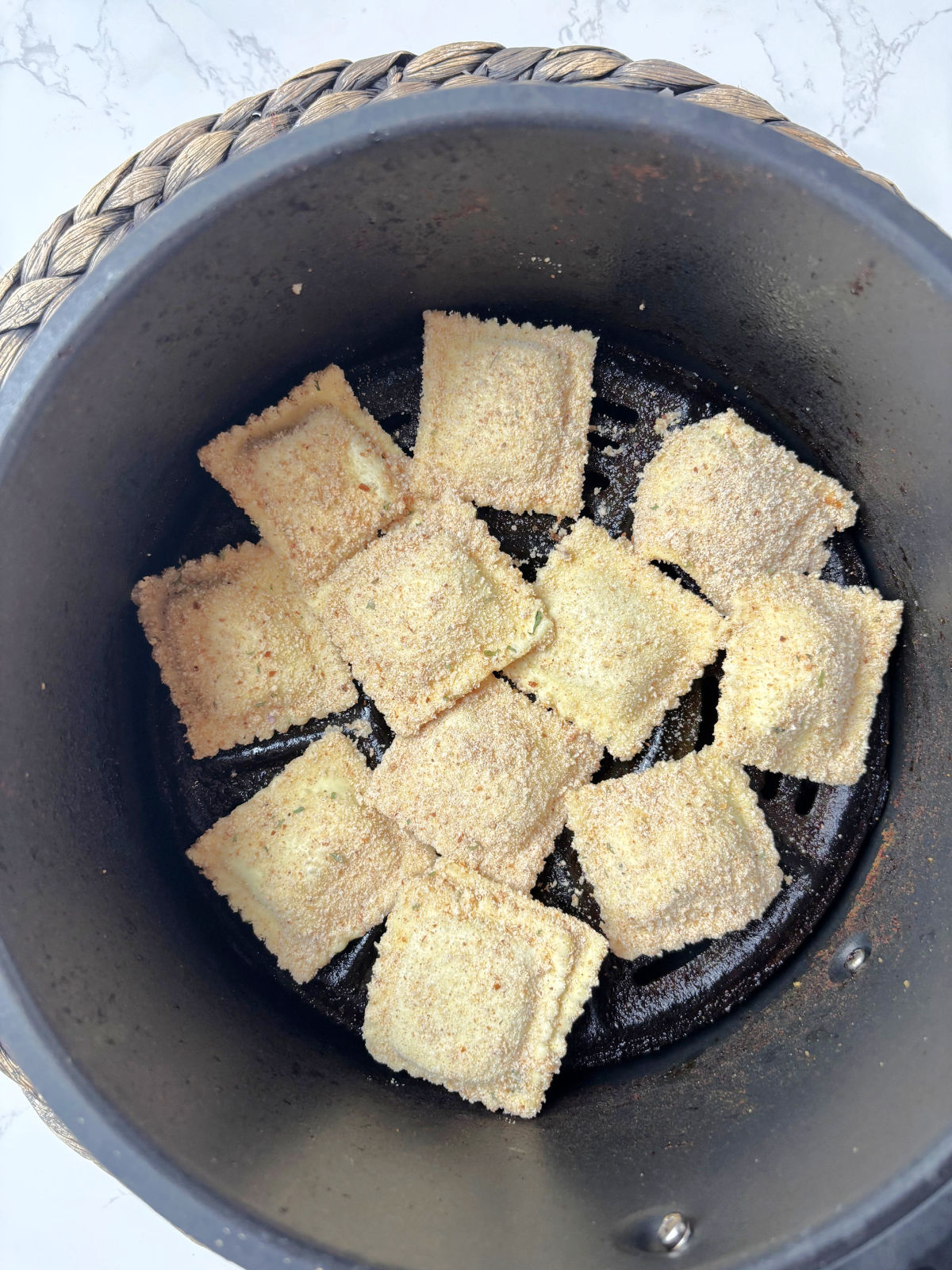 ravioli in air fryer basket.