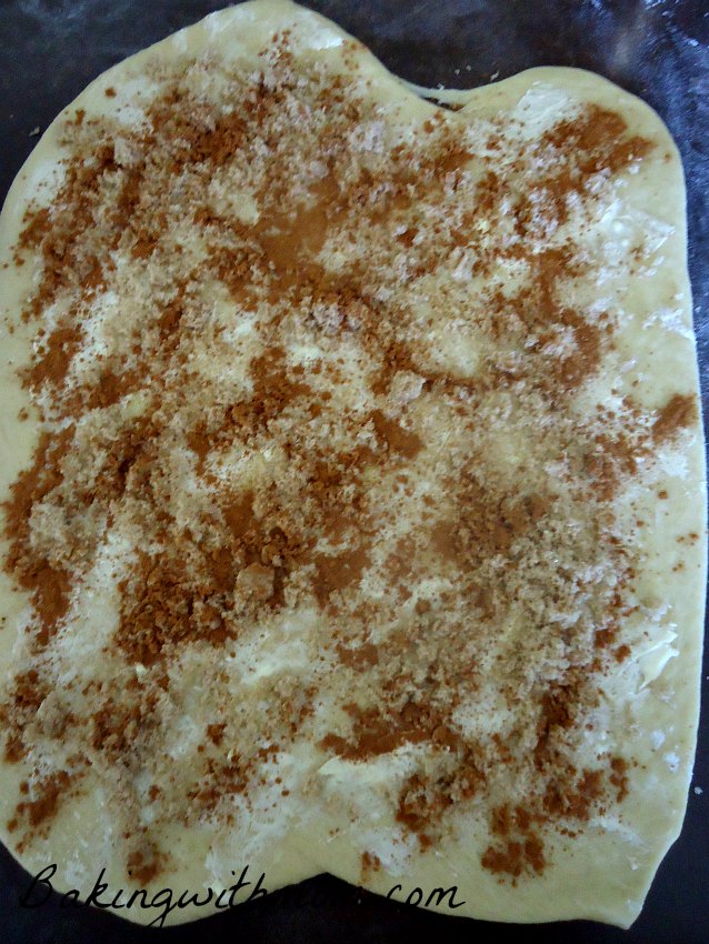 Dough rolled out with cinnamon and brown sugar sprinkled on top.