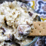 Cookie dough dip in a clear bowl with a graham cracker