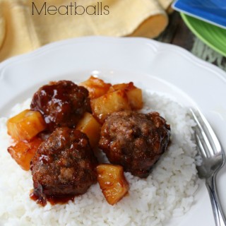 meatballs and pineapple on a bed of rice on a white plate