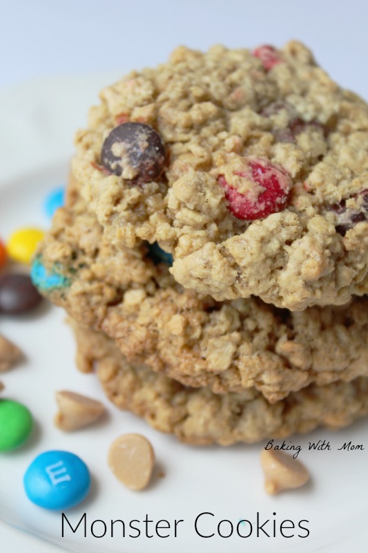 Monster Cookies with peanut butter chips, chocolate chips and M&M's on a flat white surface