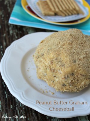 Peanut Butter Graham Cheeseball on a white plate with crackers laying behind