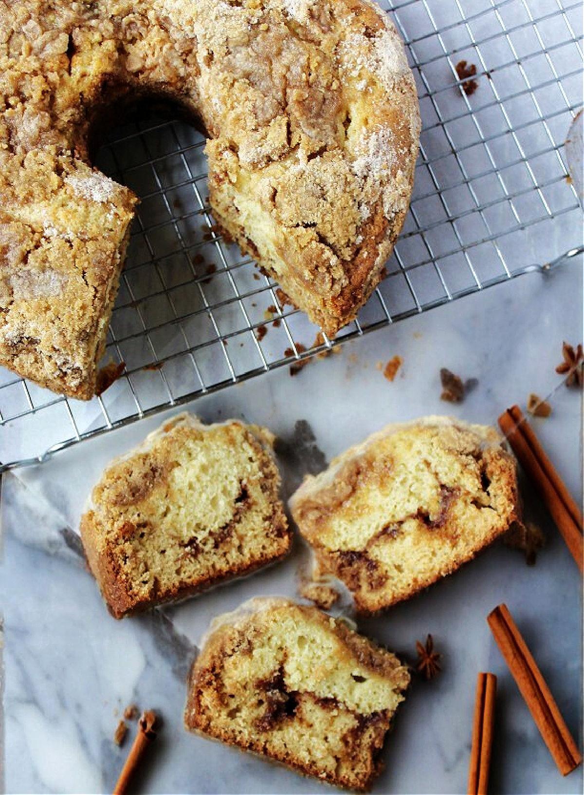 coffee cake on a cooling rack with slices nearby. 