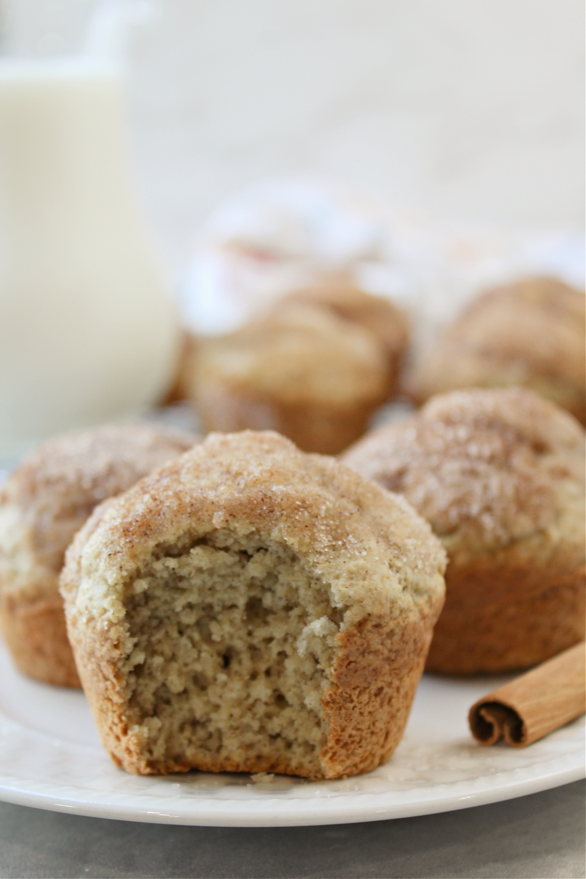 applesauce puff muffin on a white plate with a cinnamon stick nearby. 