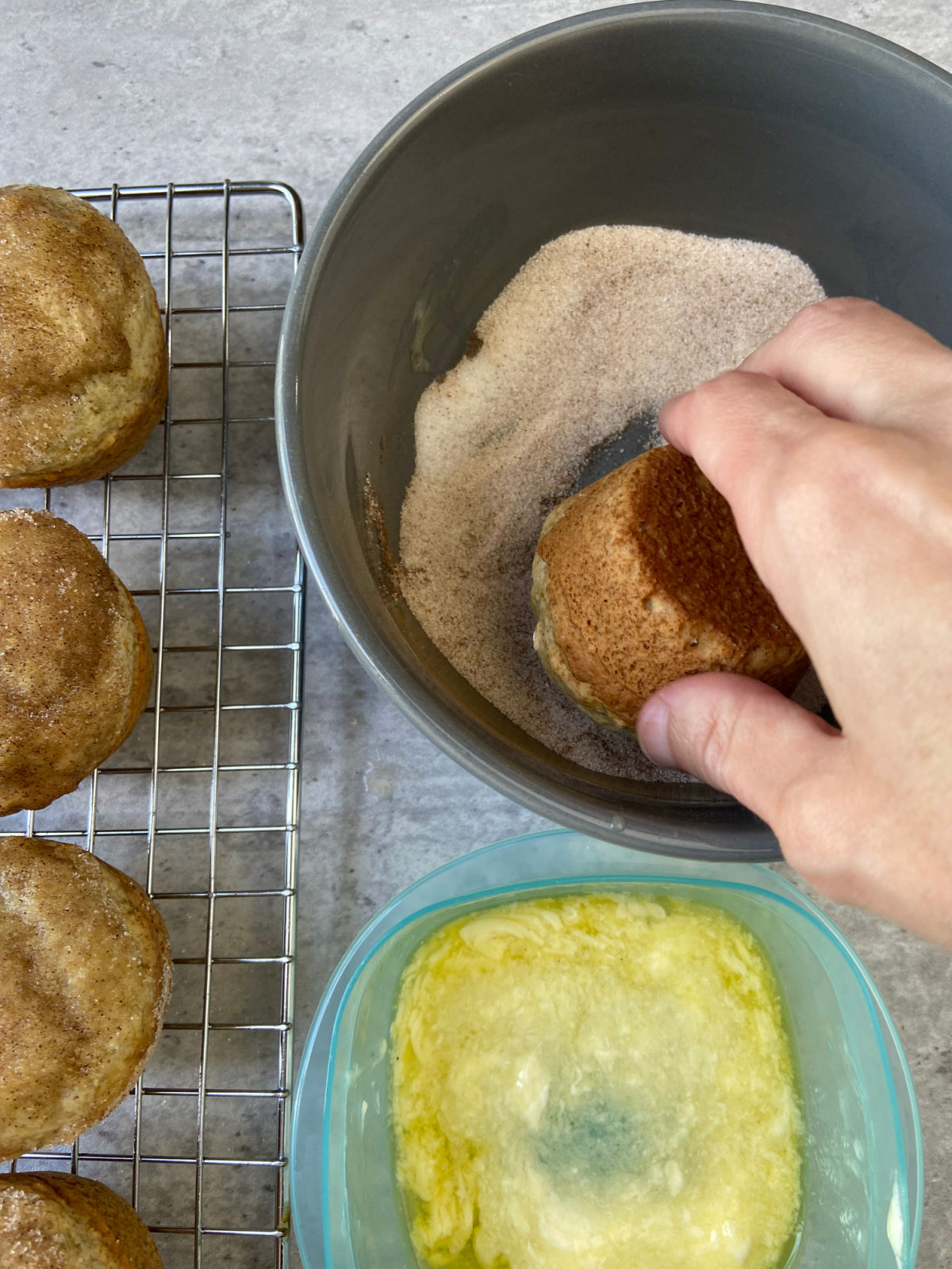 muffin being dipped in butter and cinnamon sugar. 