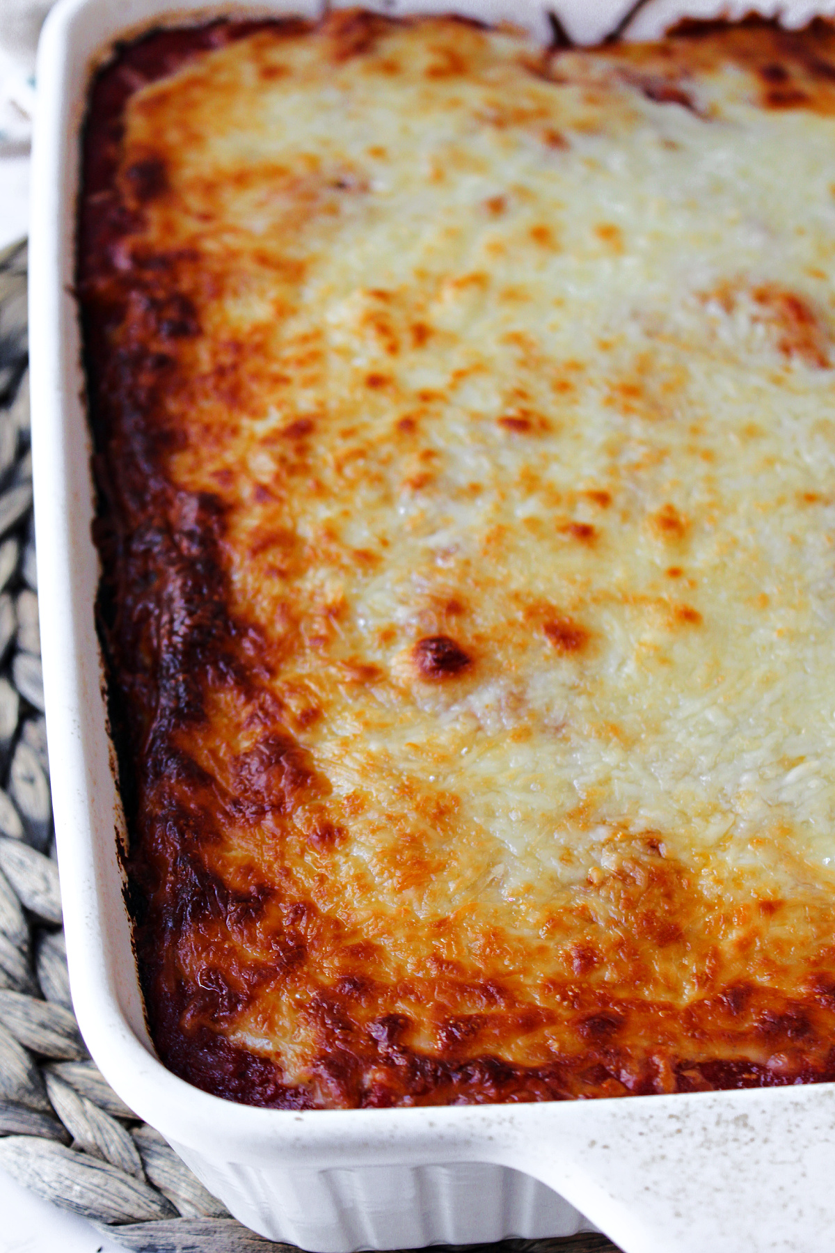 baked mostaccioli casserole in a white casserole dish.