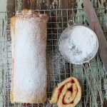 jelly roll with powdered sugar on a baking rack