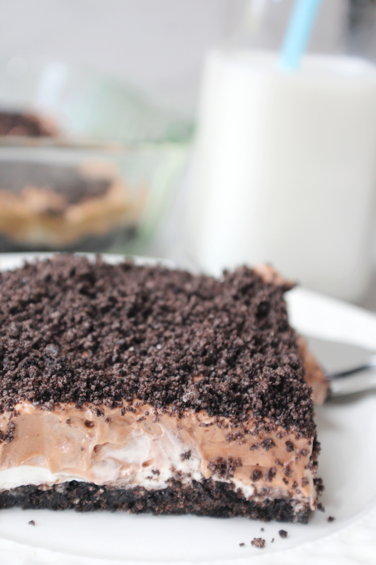 Oreo Bars on a white plate with milk behind.