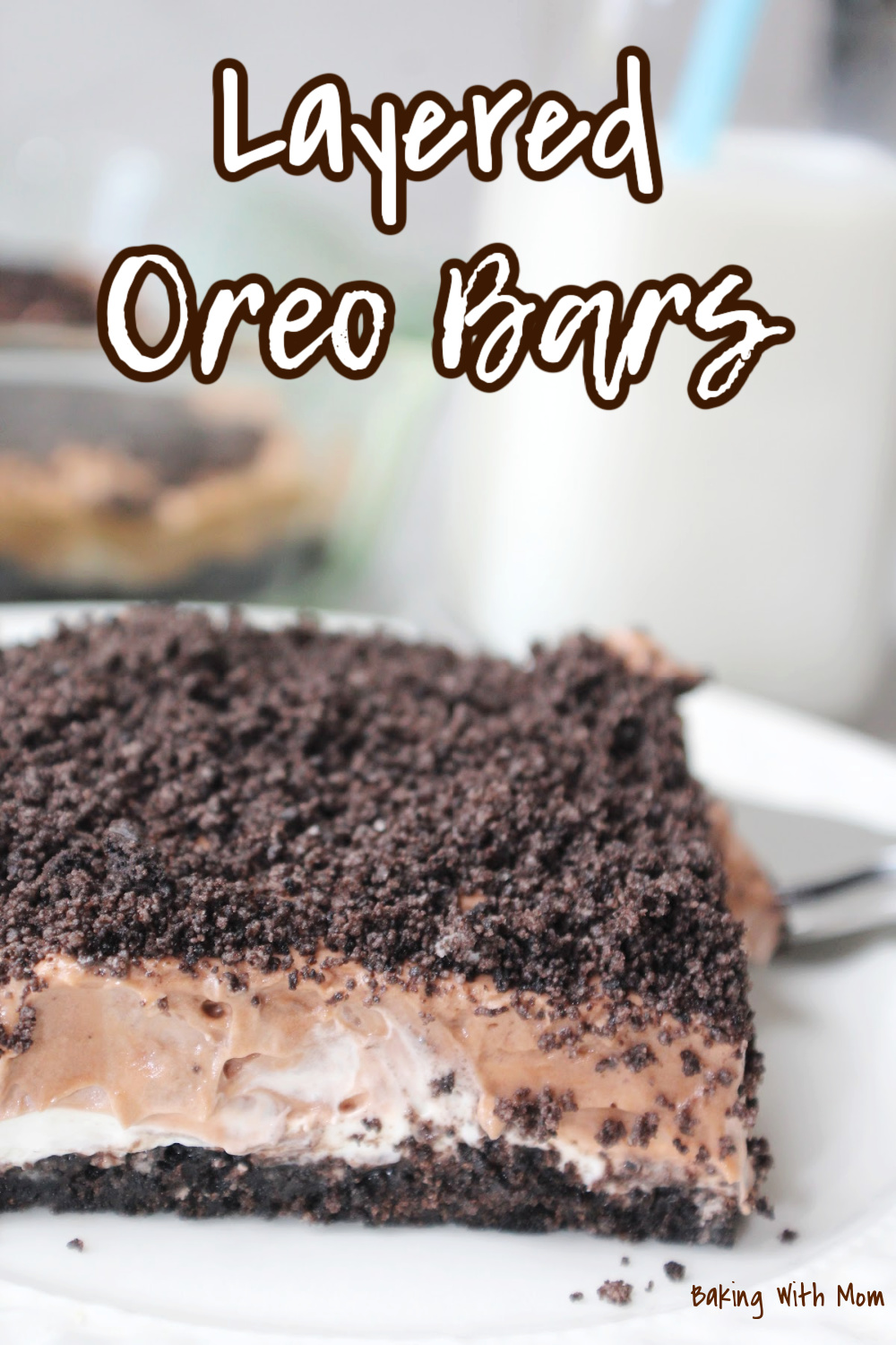 Layered Oreo Bars on a white plate with milk behind. 