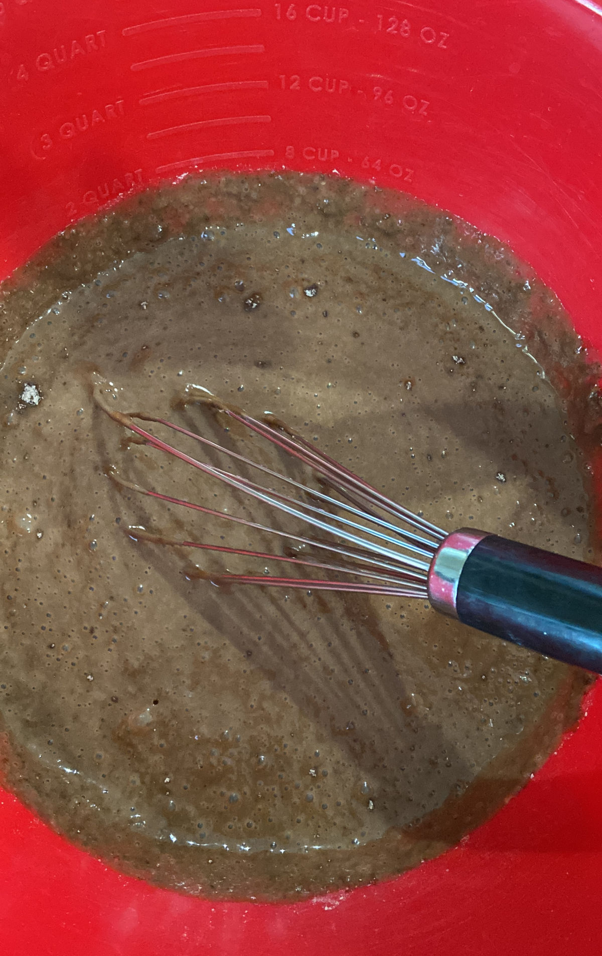 pudding in a red bowl with a whisk. 