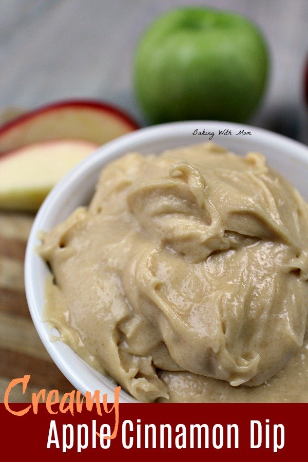 Creamy apple cinnamon dip in a white bowl and red apple slices behind