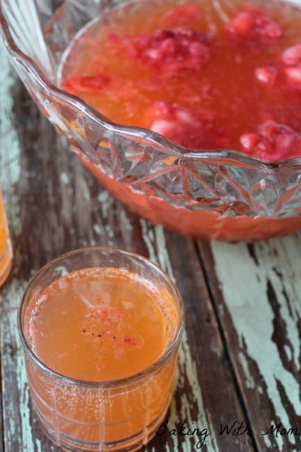 cup of strawberry punch and punch in a clear bowl. 