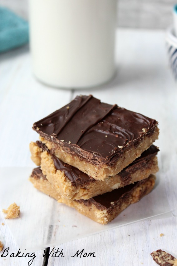 Peanut butter bars with glass of milk behind