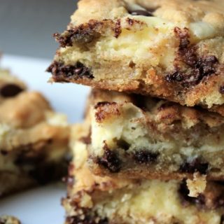 chocolate chip cheesecake bars stacked in three with one laying besides