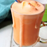 orange frosty drink on a white board.