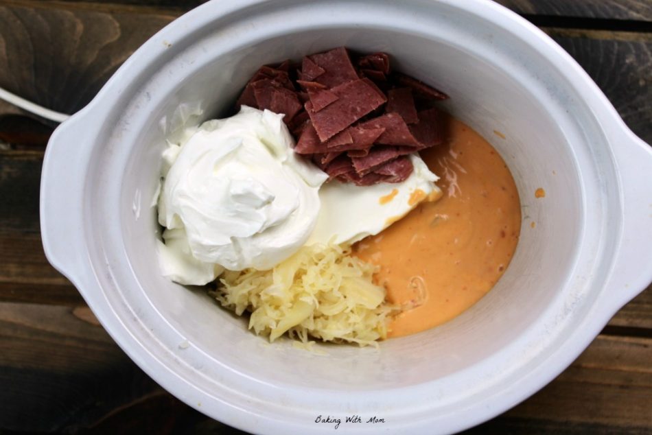 Reuben dip ingredients in a small oval crock pot