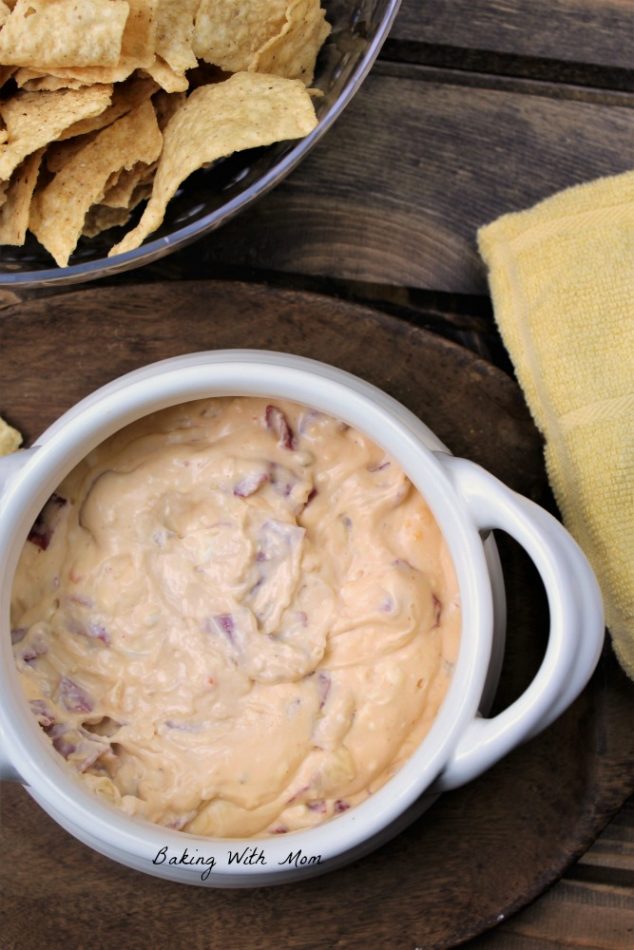 Hot Reuben Dip With Chips in a white bowl on a brown serving tray