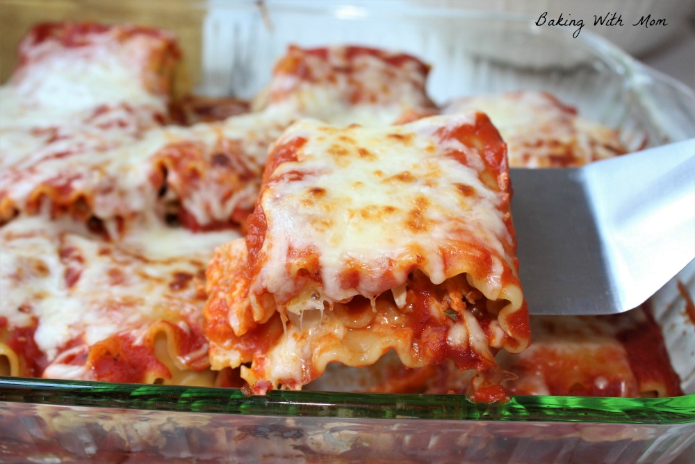 Easy Chicken Parmesan Roll Ups being held by a spatula. 