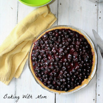 blueberry pie on a board with a towel.