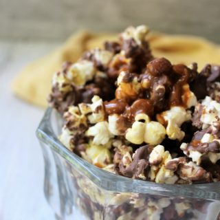 Chocolate Vanilla Swirl Caramel Popcorn in a small clear bowl with yellow towel