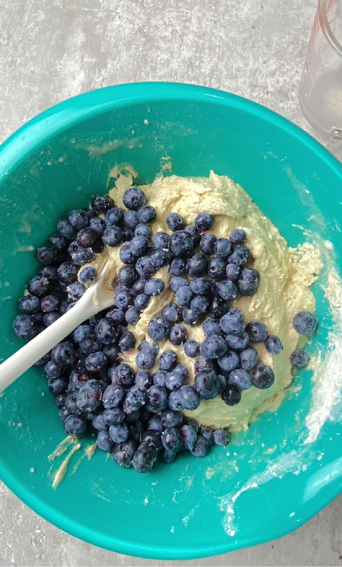 blueberries with batter in a green bowl.