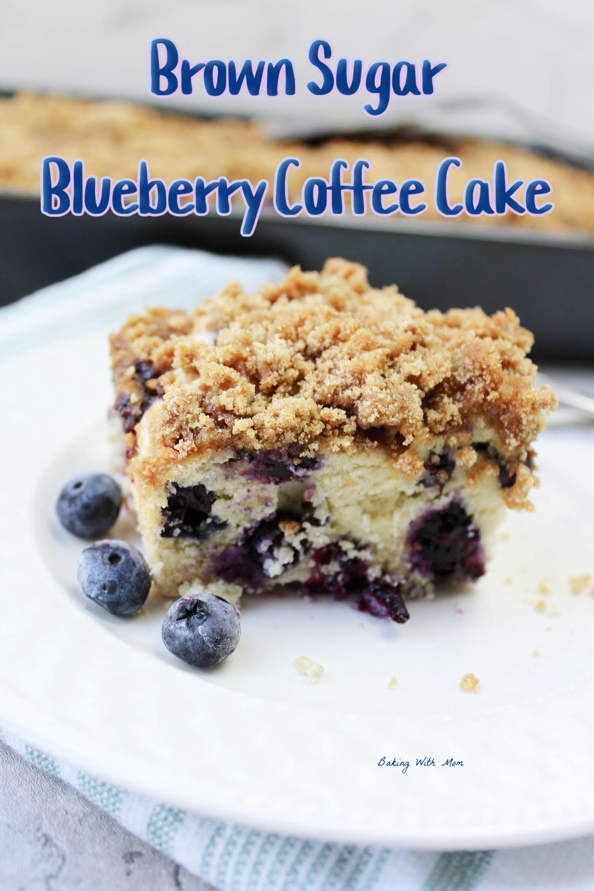 blueberry coffee cake on a white plate with blueberries.