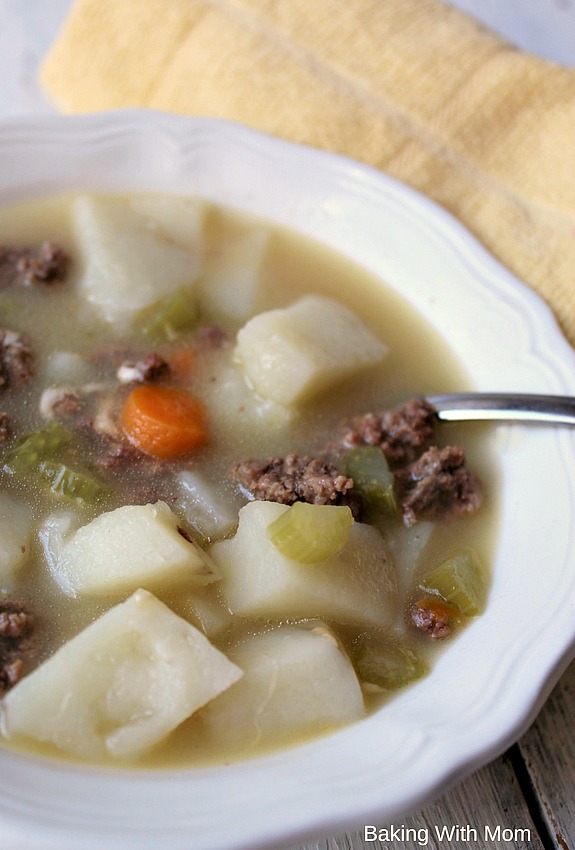 Cheeseburger Soup in a cream bowl with potatoes and carrots