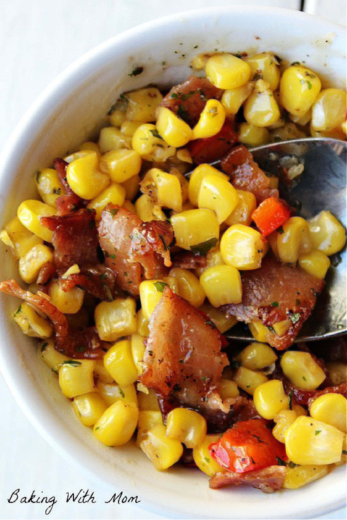 fried corn with bacon in a white bowl. 