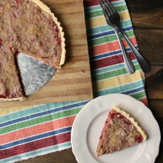 Cherry Tart With Streusel Topping with a slice on a white plate