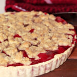 cherry tart on a brown cutting board.