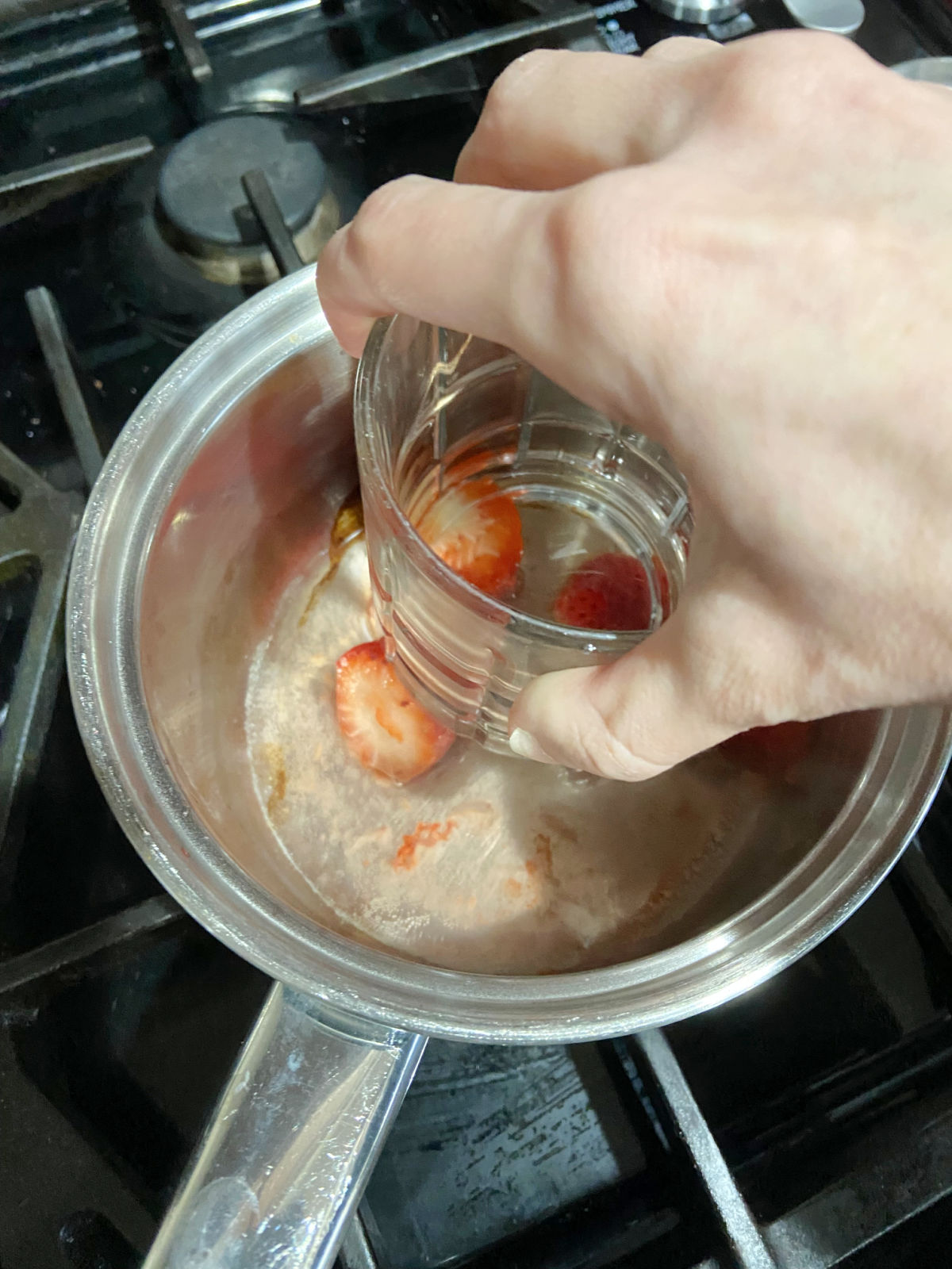 smashing strawberries in a pan. 