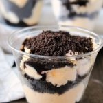 ice cream in a cup with layers of chocolate and oreo crumbs