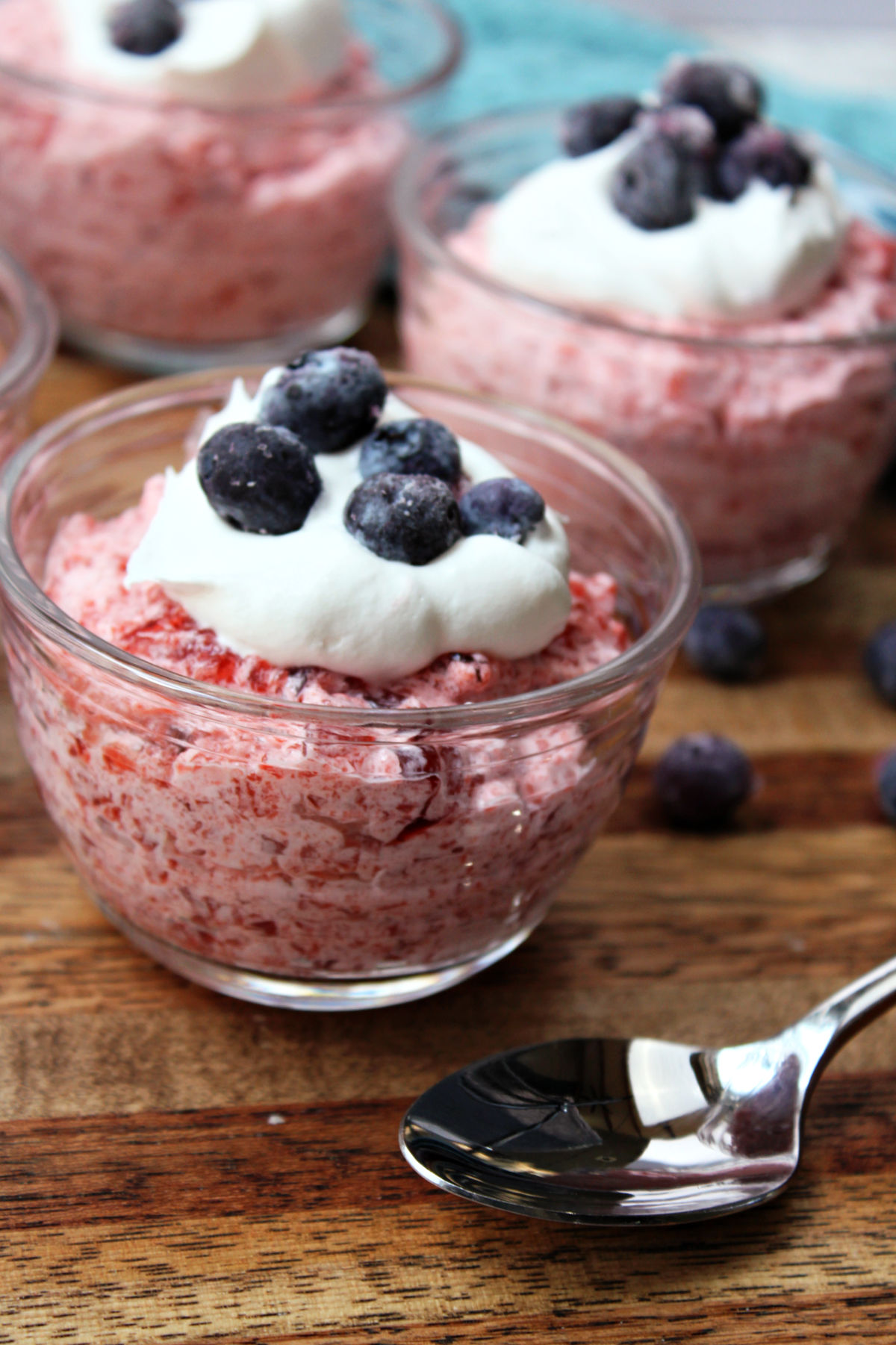 jello in a clear cup with whipped cream and blueberries.