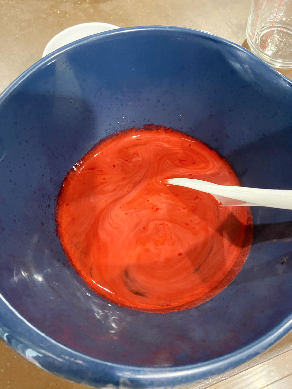 Red jello in a blue bowl. 